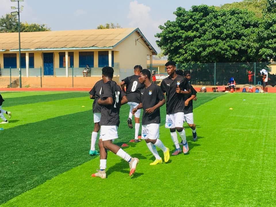 Players warming up on the training pitch at Manuel Soccer Link Academy
